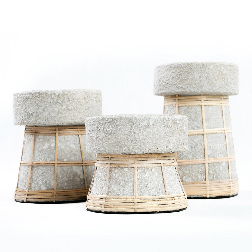 Three stools with woven bases and textured gray tops on a white background