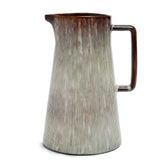 Ceramic pitcher with textured surface and brown handle on a white background