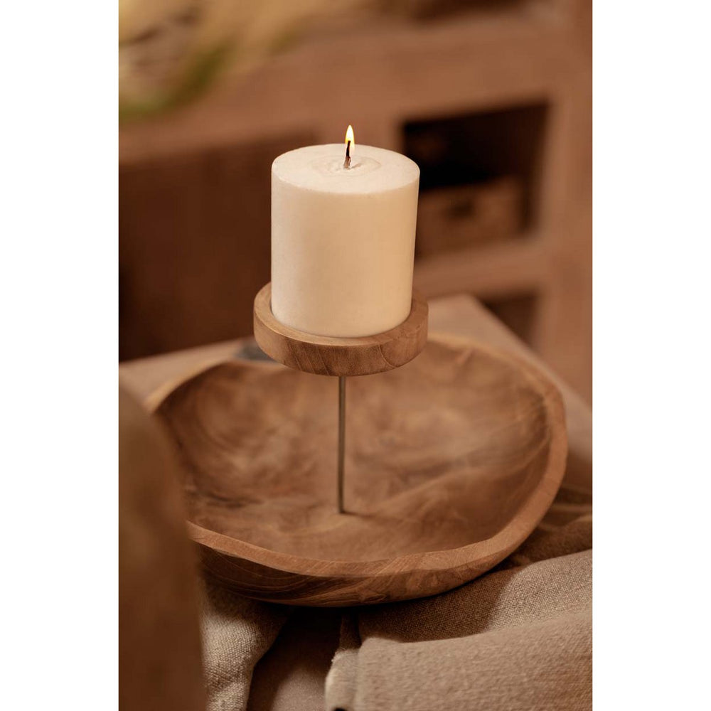 White candle on a wooden stand with a blurred background